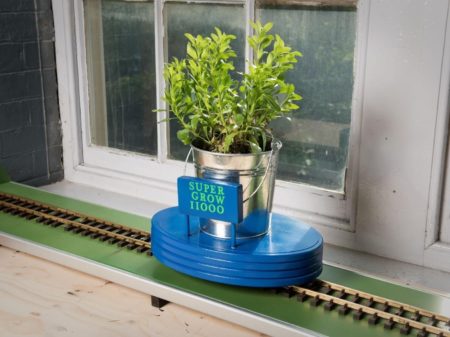 A real made version of the child's drawing showing a plant pot that moves along the train tracks