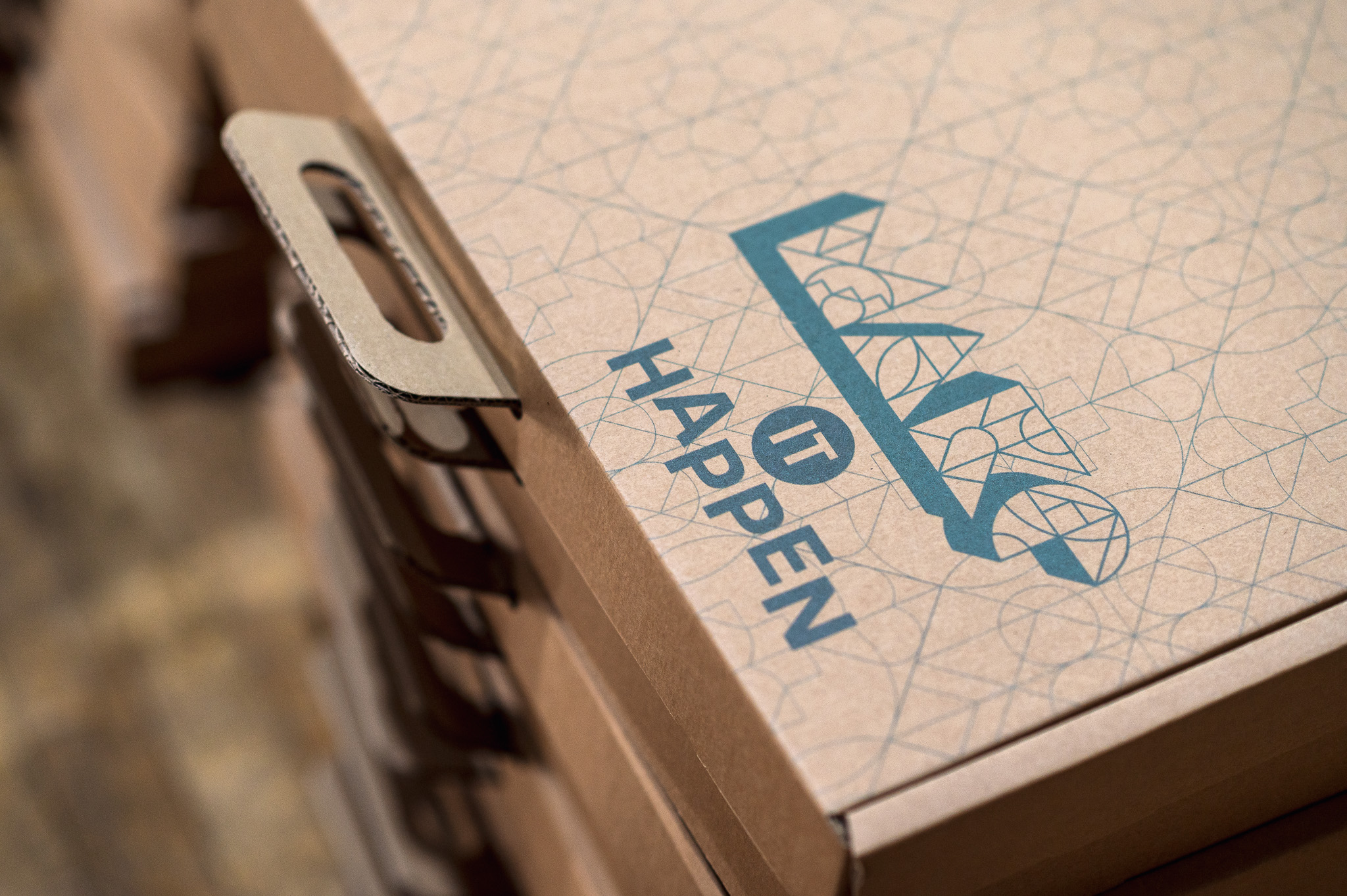 Stacked cardboard boxes with geometric patterns and bold blue text reading, 