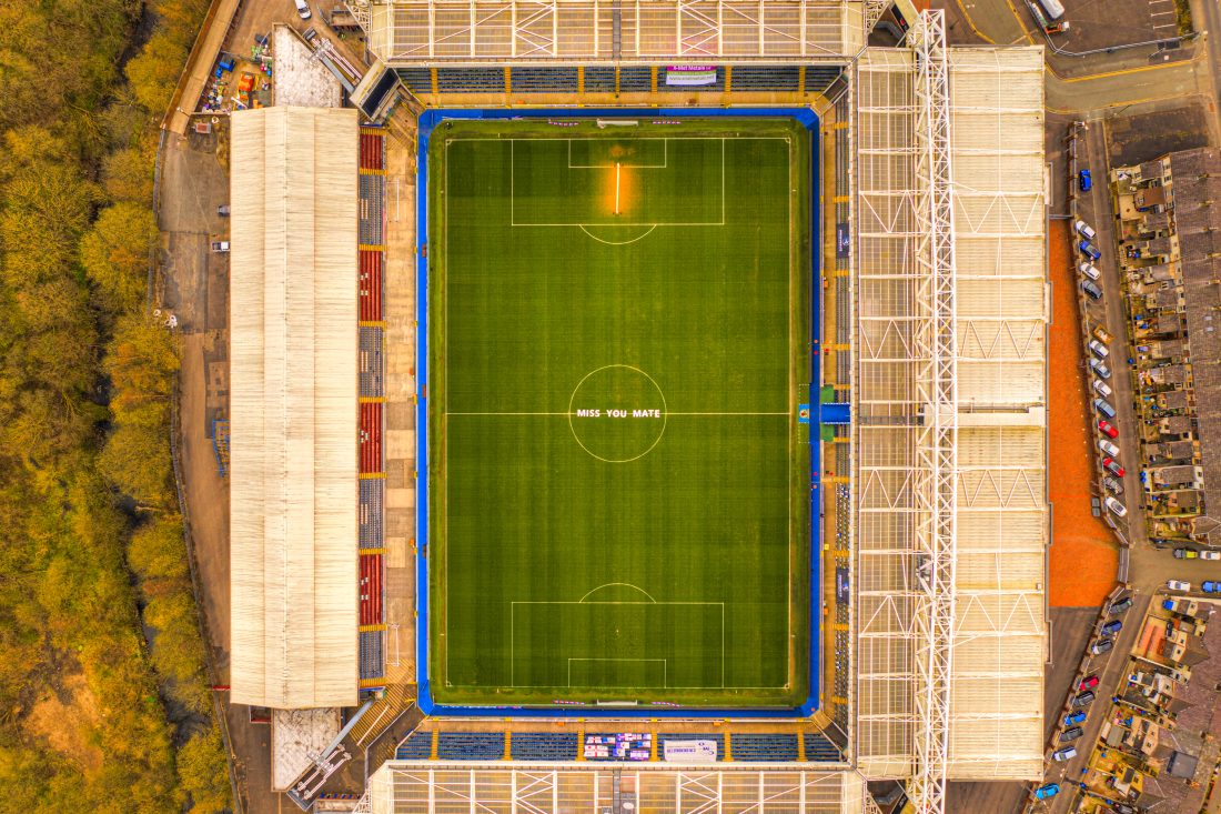 Aerial view of Blackburn rovers stadium with green field, surrounded by stands. The words "MISS YOU MATE" are visible at the centre circle.