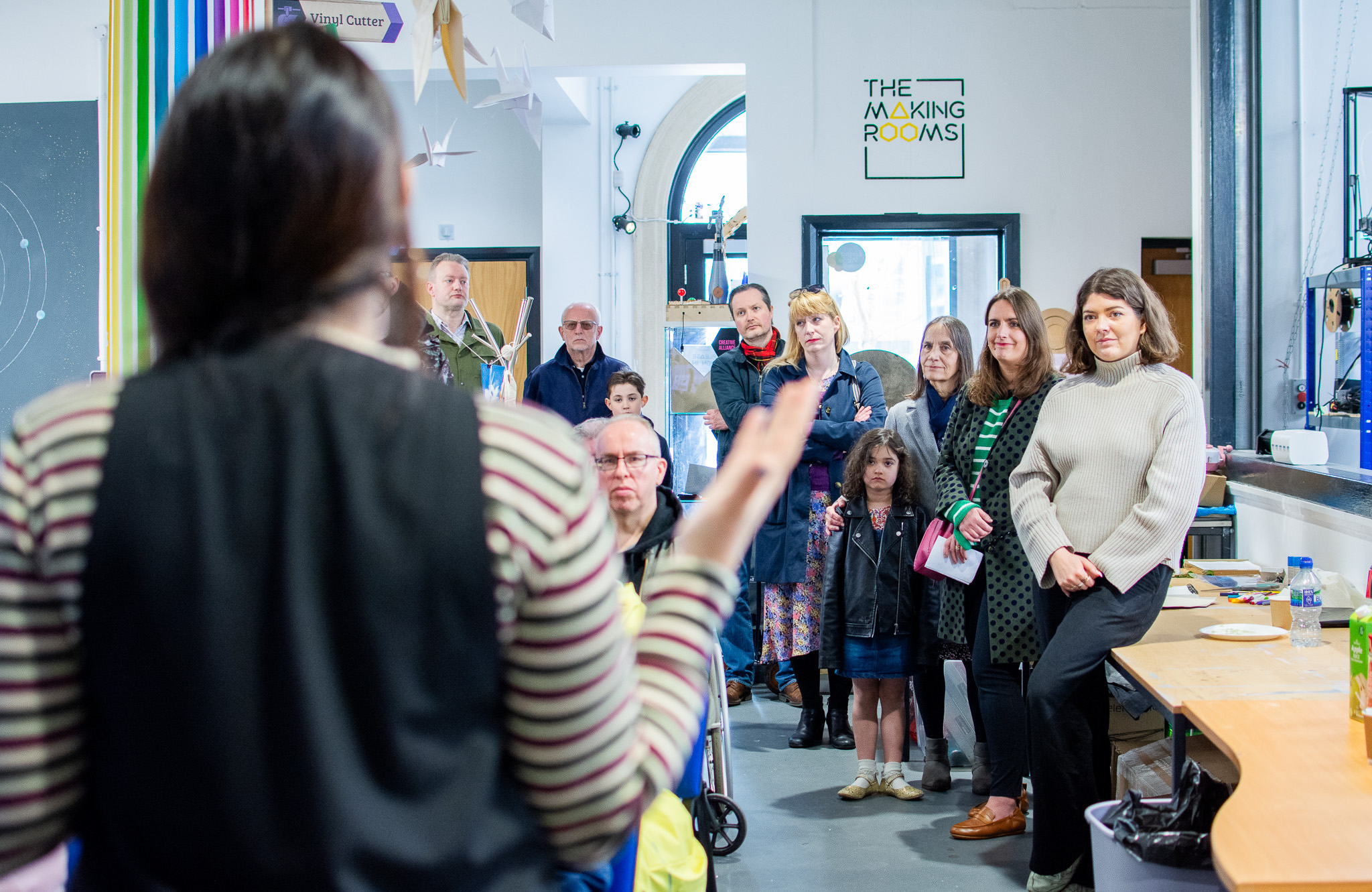 A group attentively listens to a speaker in a creative workshop space at The Making Rooms.