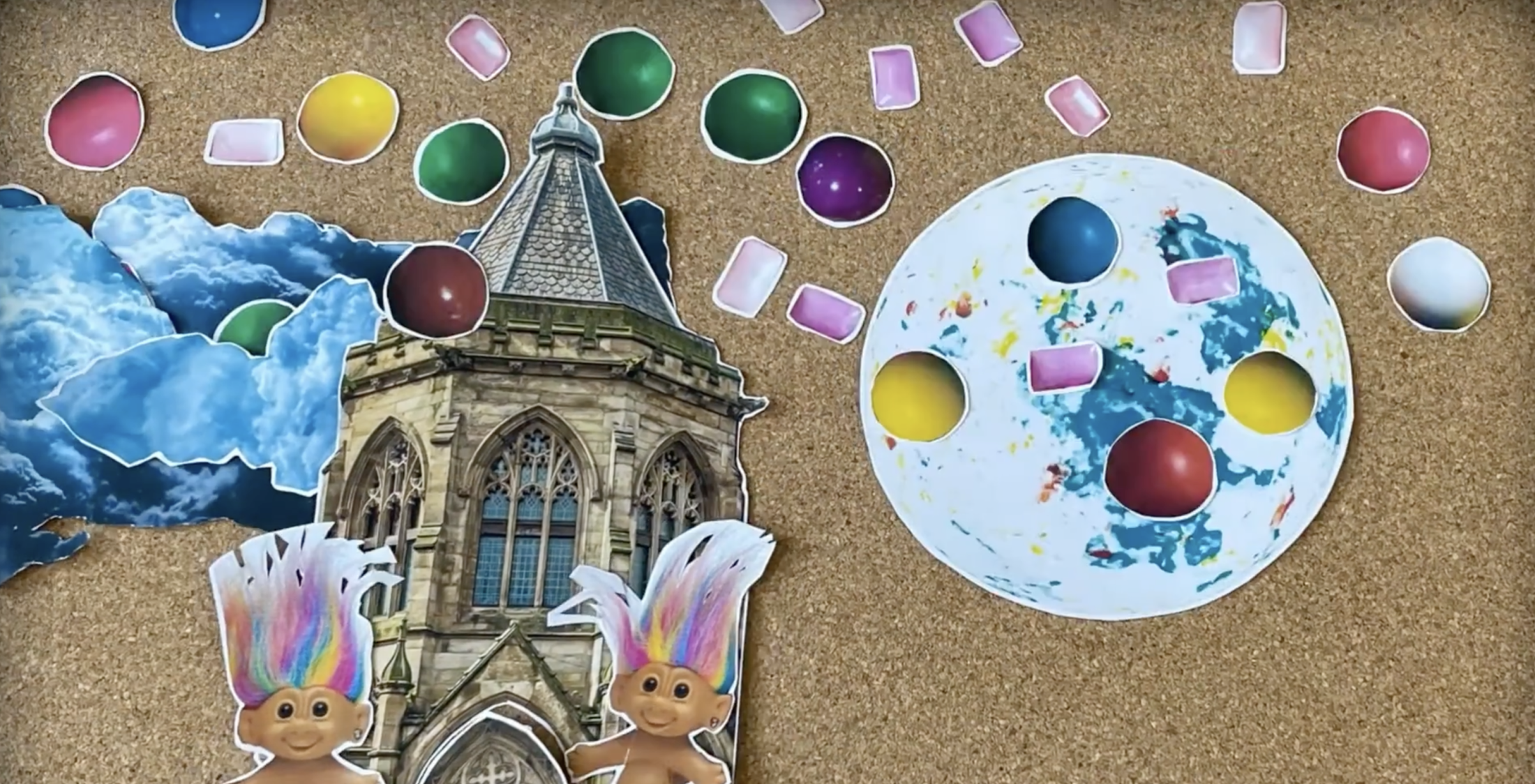 Corkboard collage with photos of an historic building, trolls, clouds, gum balls and the moon.