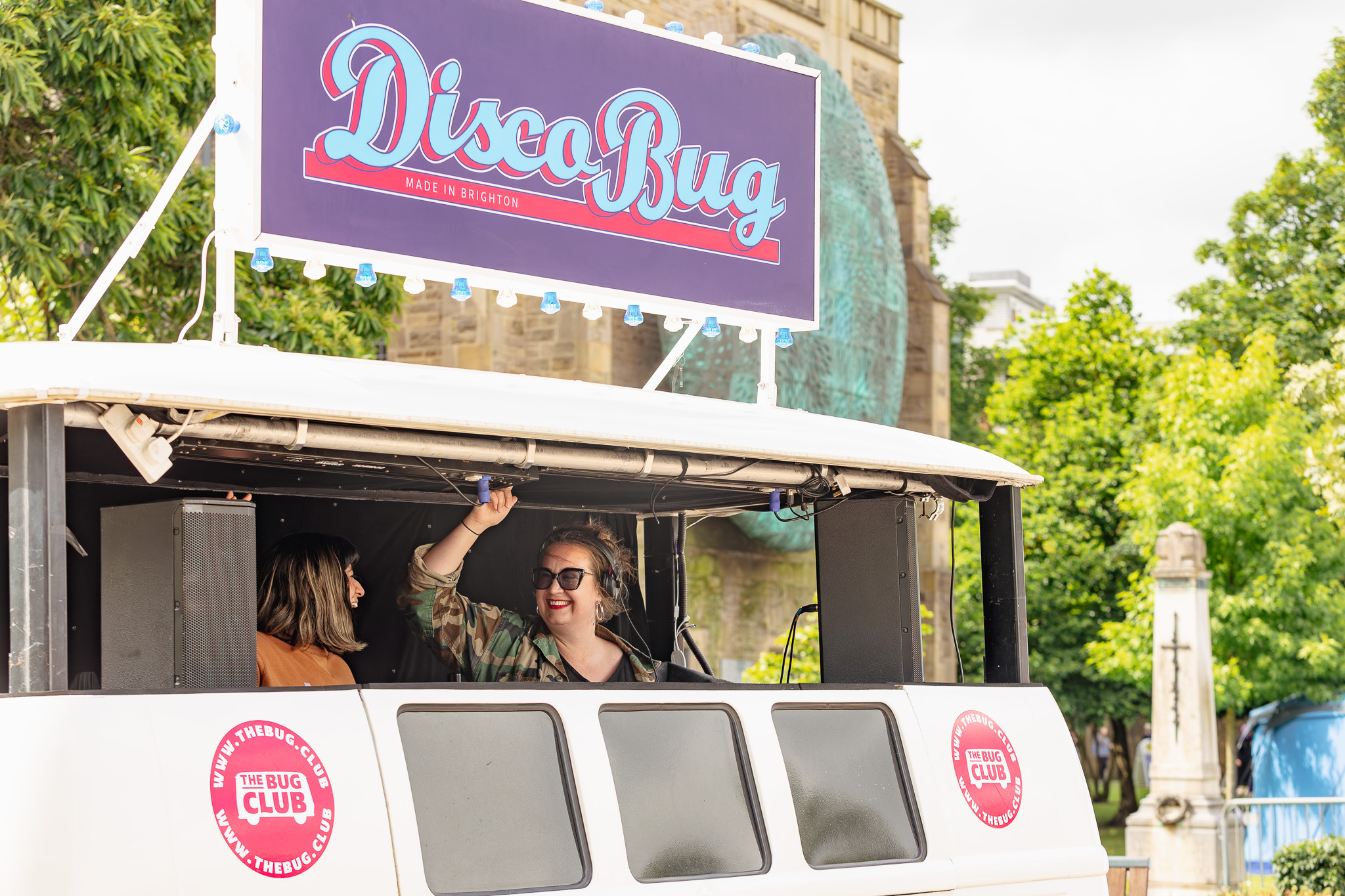 A woman in sunglasses enjoys music in a vehicle labeled 