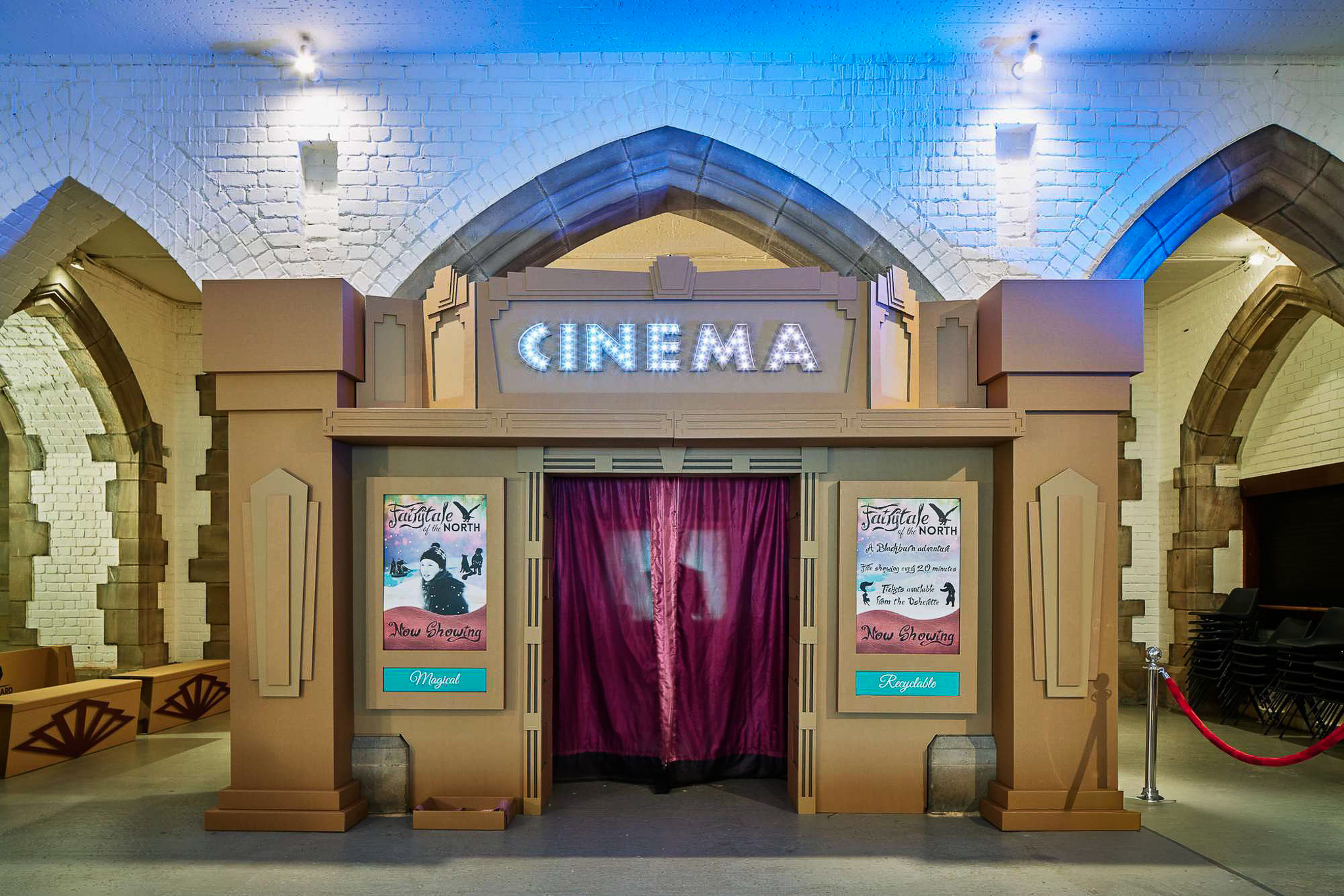Vintage-style cardboard cinema entrance with illuminated 