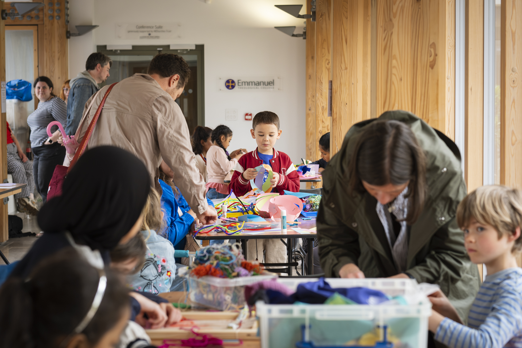 Children and adults engage in colourful crafts workshop.