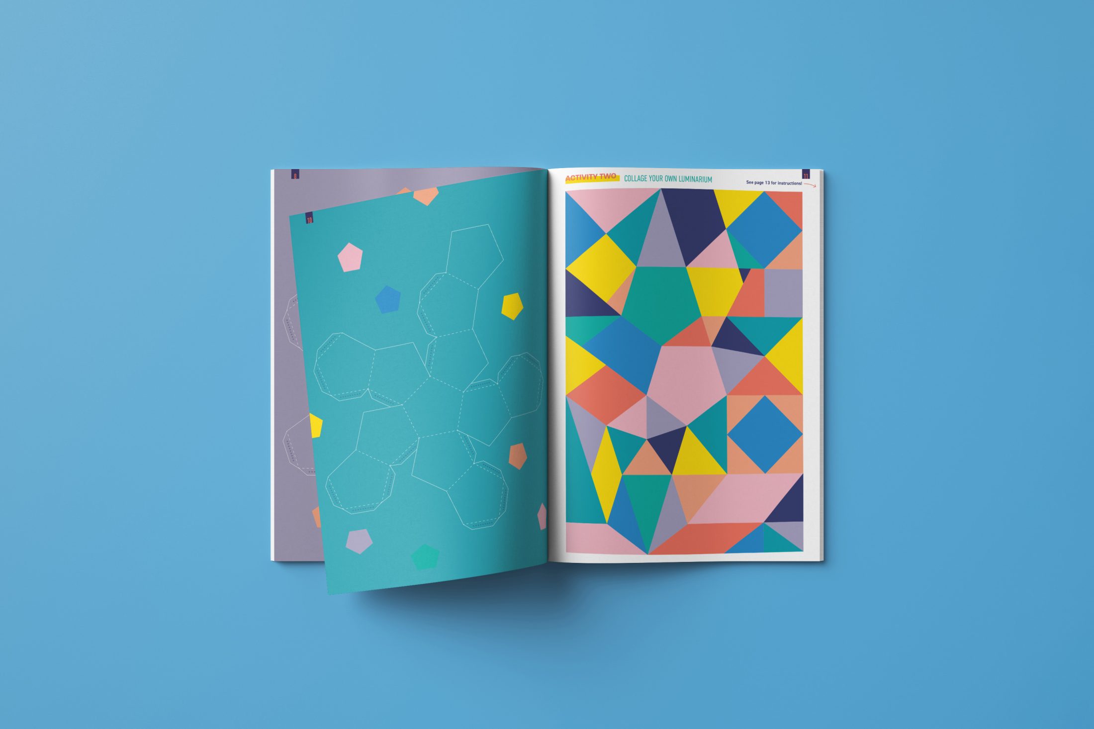 An open book on a blue surface shows colourful geometric shapes and patterns, with one page featuring outlined polygons and the other filled with vibrant triangles and quadrilaterals.