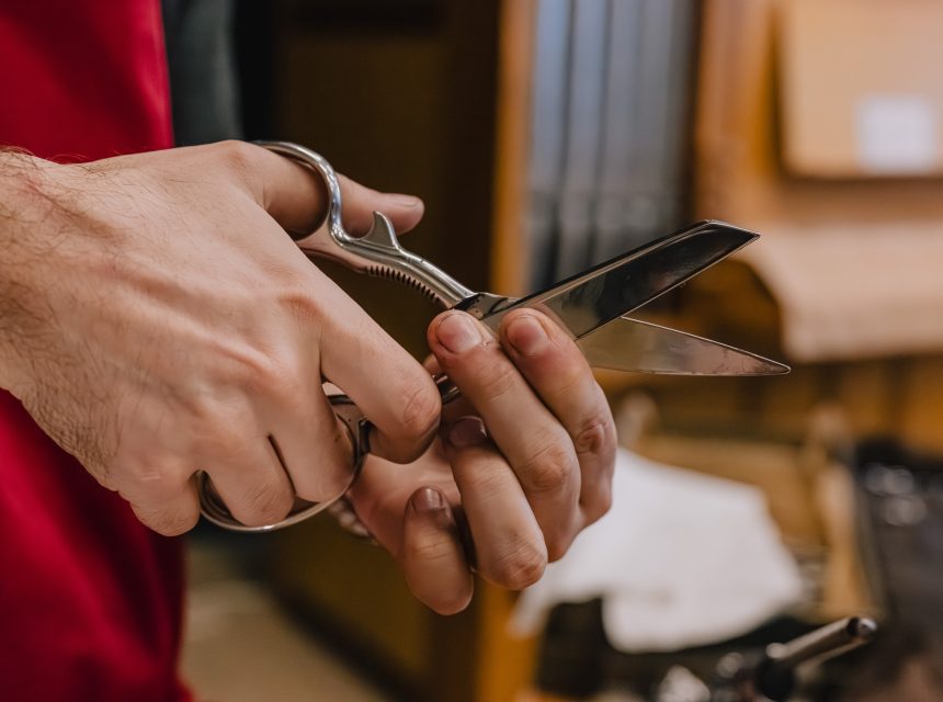 Close-up of hands holding shiny hand crafted scissors.