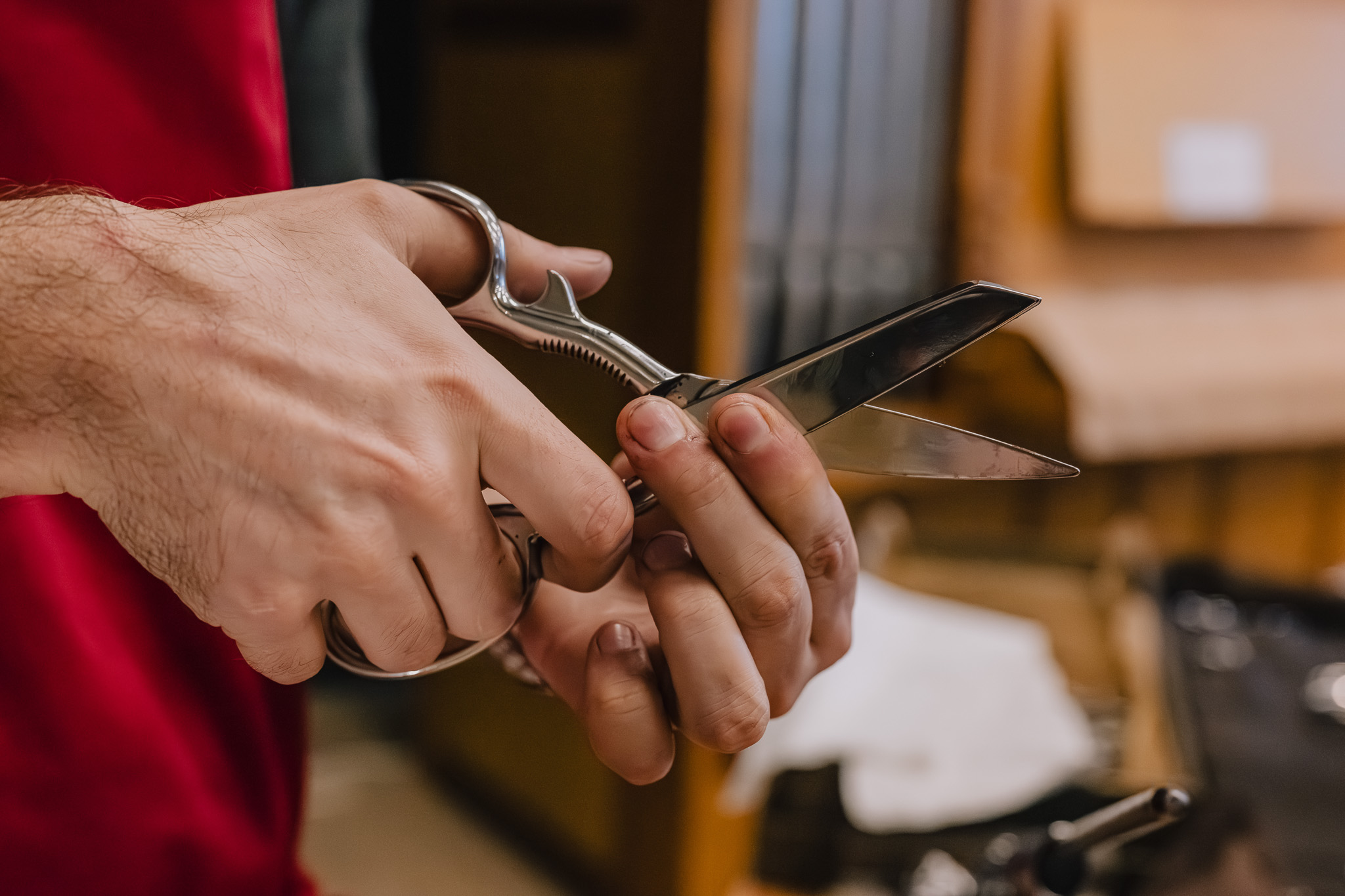 Close-up of hands holding shiny hand crafted scissors.