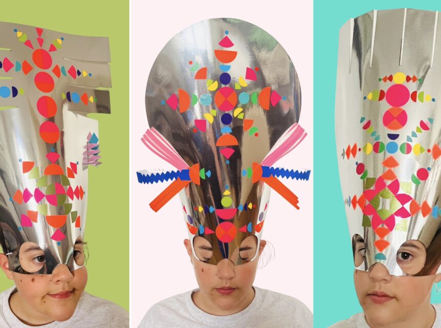 Three children wearing tall, shiny silver paper headdresses decorated with colourful geometric shapes, against green, pink, and blue backgrounds.
